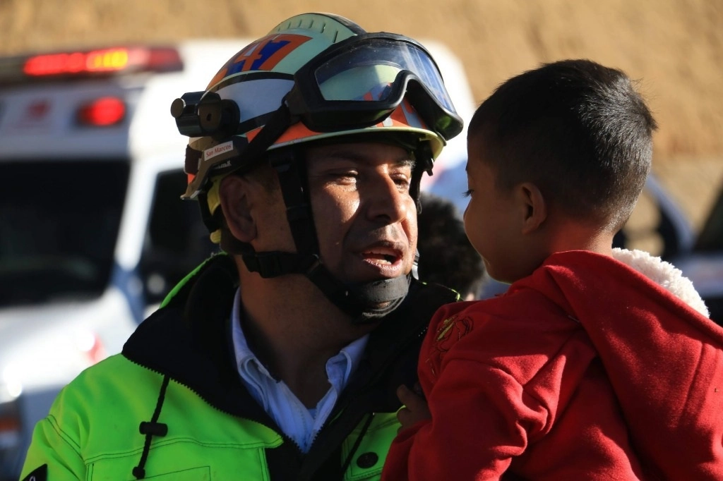Un paramédico tranquiliza a un niño que viajaba en un autobús que sufrió un accidente. Foto Cuartoscuro / Archivo 