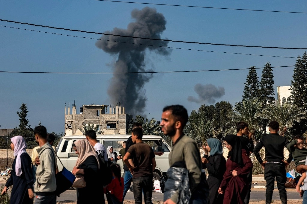 Personas huyen de la franja de Gaza entre el humo provocado por los bombardeos israelíes en la zona, el 9 de noviembre de 2023. Foto Afp