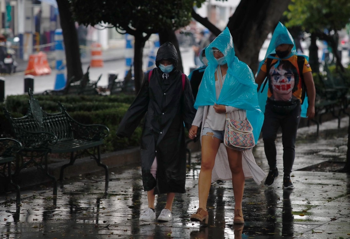 Transeúntes bajo la lluvia, esta tarde. Foto: Cristina Rodríguez