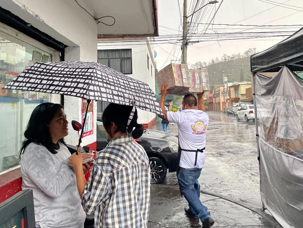 Gente se cubre de la lluvia con paraguas, cajas o bolsas de plástico, ayer durante la lluvia que se registró por la tarde en varias zonas de la CDMX. Foto Roberto García Ortiz