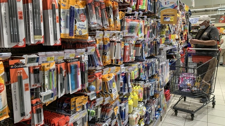 Un hombre compra material escolar en un supermercado. Foto Afp