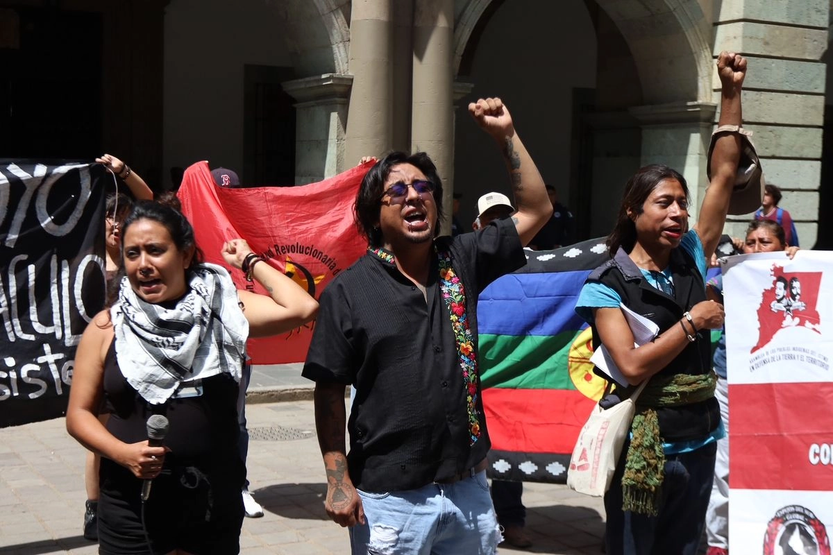 Mario Castillo Quintero (centro), del comité organizador, junto a otros integrantes del evento, ayer en el zócalo de la capital oaxaqueña.