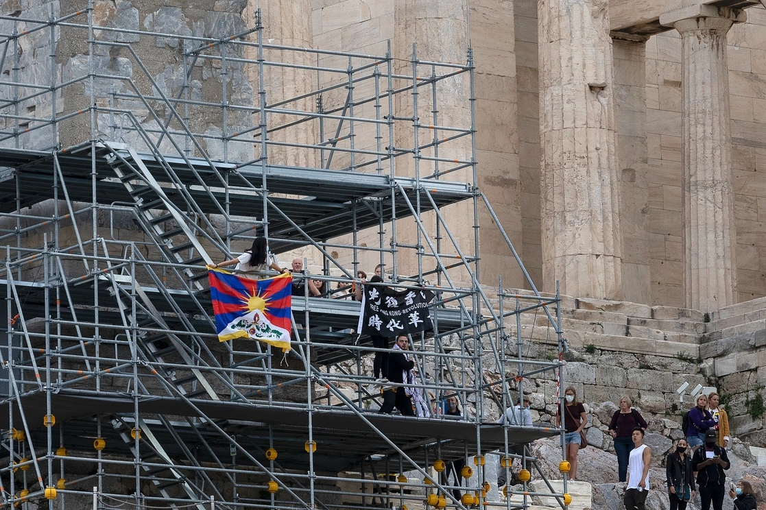 Los activistas protestaron en la Acrópolis, en Grecia, con la bandera tibetana y la bandera de la revolución de Hong Kong.  Foto Ap