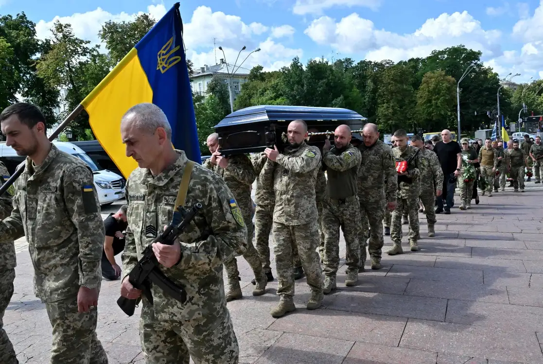 Militares ucranios trasladan el ataúd de un compañero en su funeral en Kiev, el 18 de julio de 2022. Foto Afp