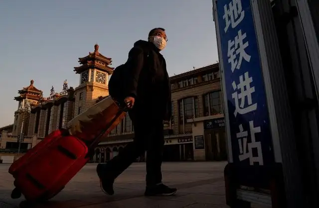 Viajeros con mascarillas en la estación de trenes de Pekín. Foto Afp 