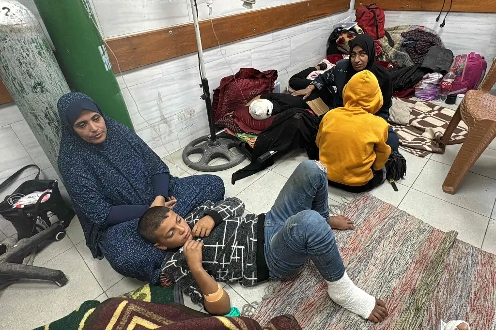Mujeres y niños esperan atención médica sentados en el suelo de la sala de traumatología del Hospital Kamal Adwan en Beit Lahia, en el norte de la Franja de Gaza, el 24 de octubre de 2024. Foto Afp
