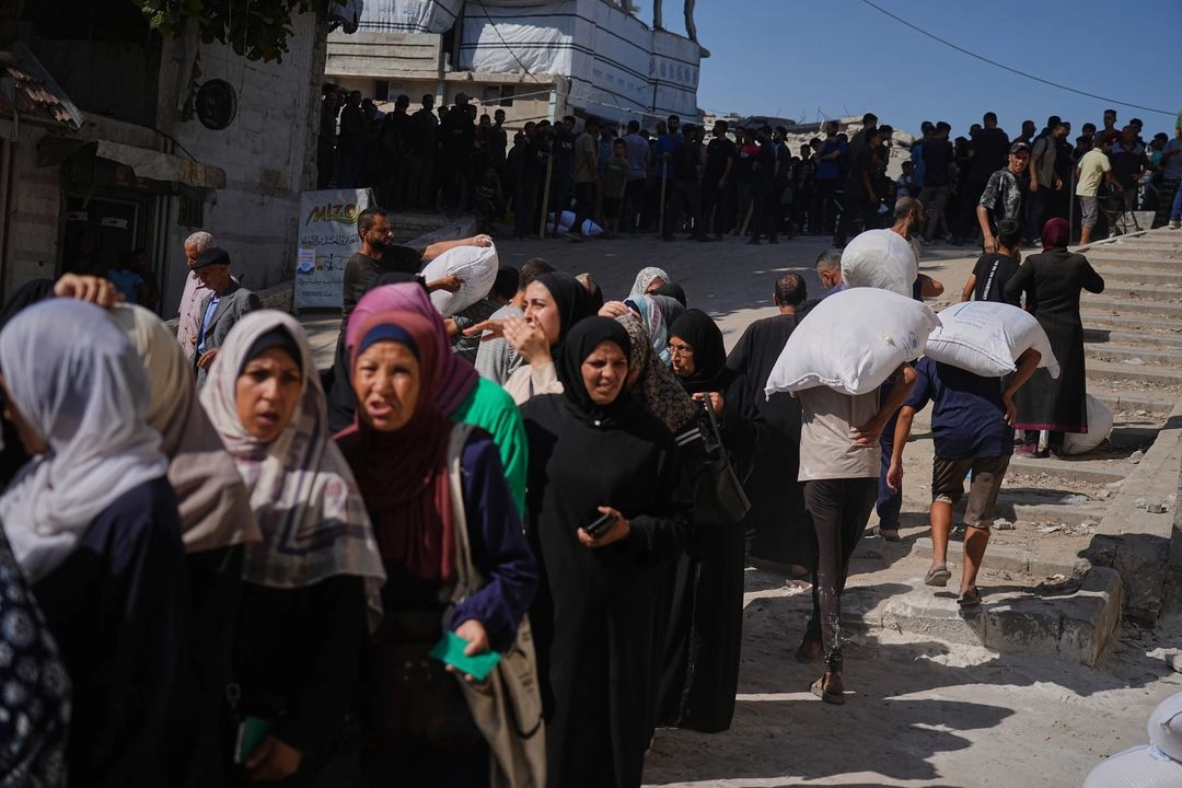 Palestinos hacen fila para recibir bolsas de harina distribuidas por el Programa Mundial de Alimentos (PMA) en la ciudad de Gaza, al norte de la Franja, el jueves 26 de junio de 2025. Foto 