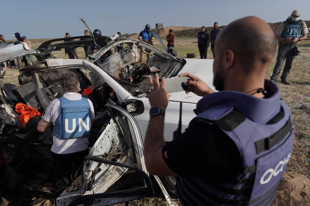 Miembros de la ONU inspeccionan lo que quedó de un auto del grupo de ayuda World Central Kitchen, tras un bombardeo israelí. Foto Afp 