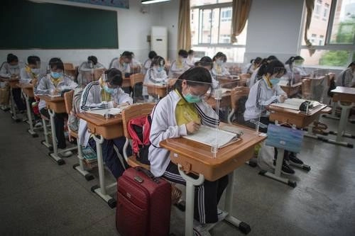 Casi 60 mil estudiantes de último año de secundaria volvieron a clases en la ciudad china de Wuhan, donde las autoridades colocaron tableros transparentes en cada escritorio para evitar contagios. Foto Xinhua