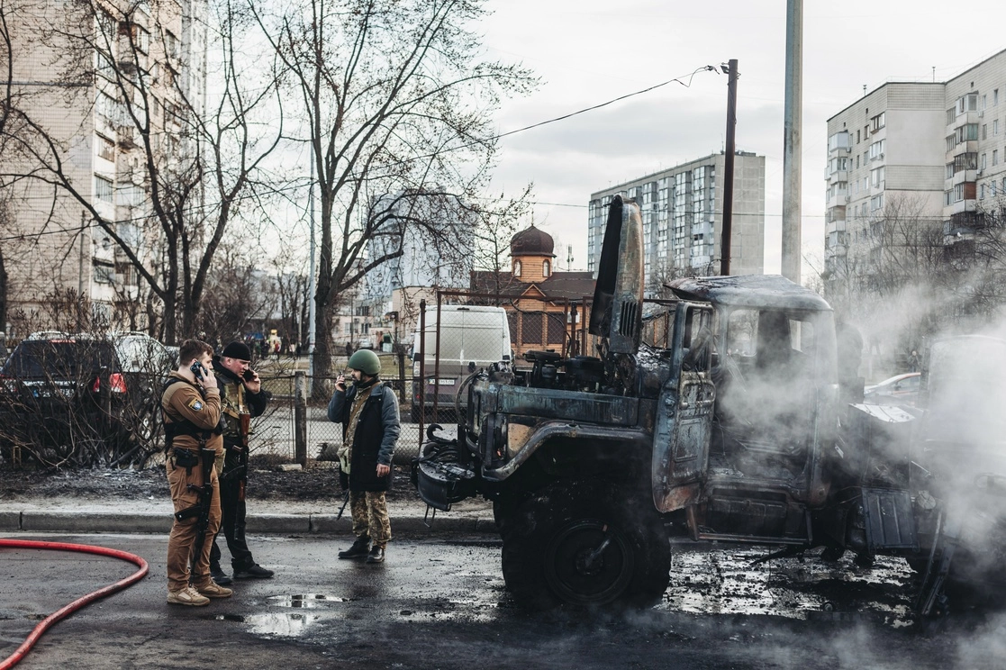 Soldados del ejército ucranio observan un vehículo militar calcinado en Kiev, capital ucrania, el 25 de febrero de 2022. Foto Europa Press