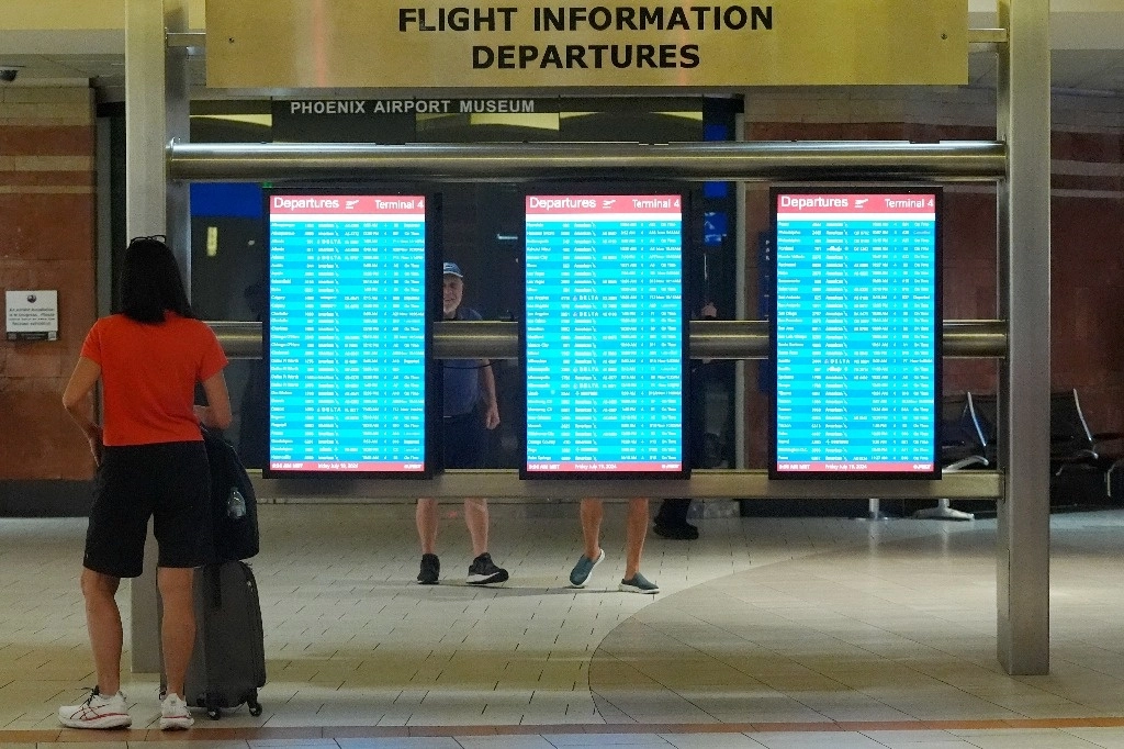 Los pasajeros revisan las pantallas de salida en el Aeropuerto Internacional Phoenix Sky Harbor el viernes 19 de julio de 2024, en Phoenix. Foto Ap