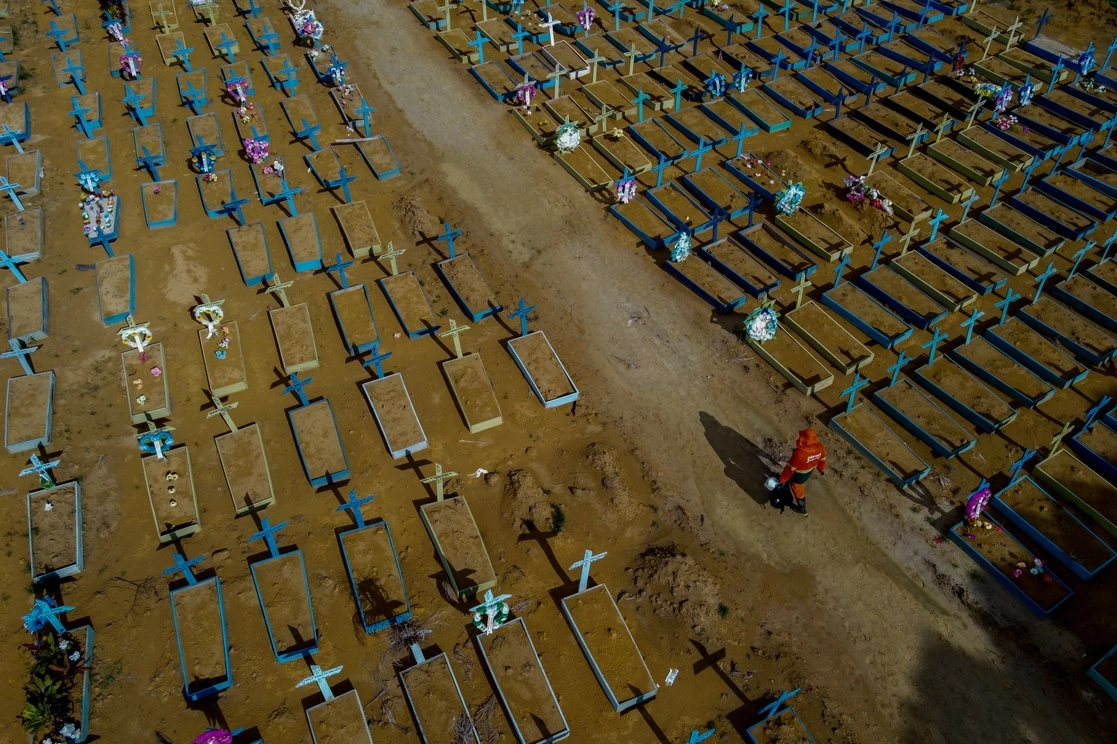 Ayer, Brasil superó la cifra de 400 mil muertes por Covid-19. En la imagen, un sepulturero camina entre tumbas de víctimas del virus en el cementerio de Nuestra Señora Aparecida, en Manaos, estado de Amazonas, el 29 de abril de 2021. Foto Afp