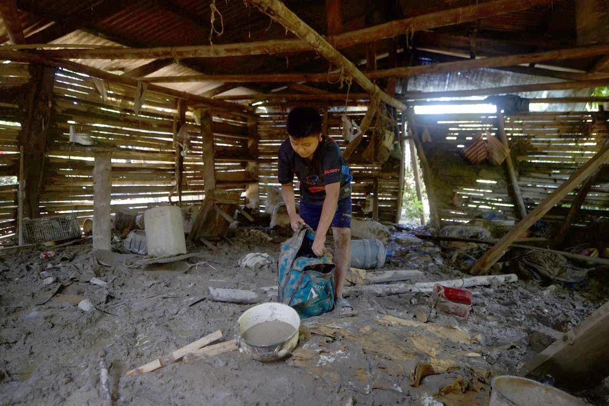 Un niño de la comunidad La Máquina, Veracruz, afectada tras el desbordamiento del río Pantepec que inundó la carretera, intenta rescatar algunas pertenencias. 