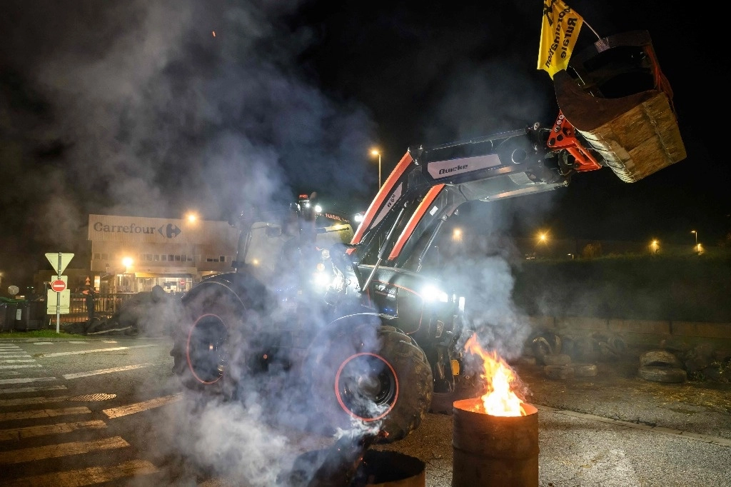 Miembros de la Coordinación Rural (CR), un sindicato agrícola francés de línea dura, bloquean la entrada a un centro de distribución de supermercados Carrefour en Colomiers, en las afueras de Toulouse, el 22 de noviembre de 2024. Foto Afp