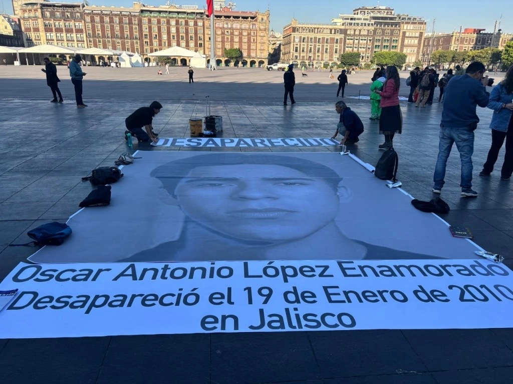 Ana Enamorado, madre de Óscar Antonio López Enamorado, acompañada de familiares de personas desaparecidas, voluntarios y activistas exigieron justicia enfrente de Palacio Nacional con un cartel de su rostro, a 15 años de su desaparición forzada en el estado de Jalisco cuando él emprendía un viaje a Estados Unidos. Después de once años, Ana, integrante de la Red Regional, sigue buscando a su hijo y acompaña a familias que siguen en la misma búsqueda. Foto María Luisa Severiano


