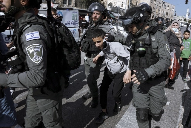 Policías israelís detienen a un ciudadano palestino durante las protestas. Foto Ap