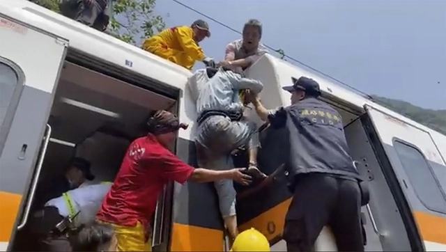 Socorristas auxilian a pasajeros del tren. Foto Ap