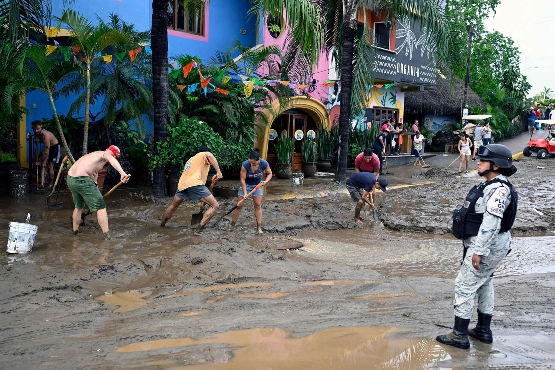 Personas laboran en actividades de limpieza en calles de Sayulita, Nayarit, tras el paso de ‘Roslyn’. Foto Afp / Archivo