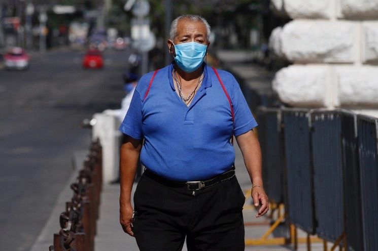 Un hombre con cubrebocas camina por calles de la CDMX. Foto Cristina Rodríguez