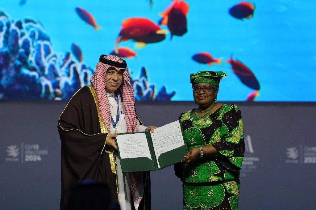 La Directora General de la Organización Mundial del Comercio, Ngozi Okonjo-Iweala, y el Ministro de Comercio e Inversiones de Arabia Saudita, Majid al-Qasabi, se dan la mano durante una sesión sobre subvenciones a la pesca durante la 13.ª Conferencia Ministerial de la OMC en Abu Dhabi el 26 de febrero de 2024. Foto Afp