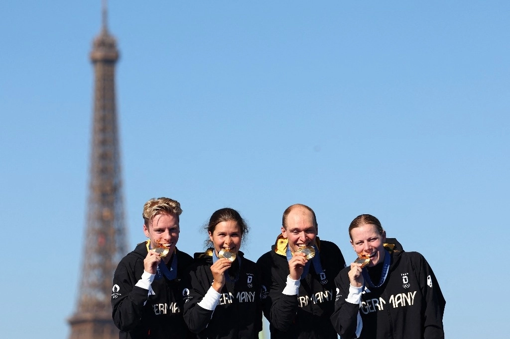 Los medallistas de oro de Alemania Tim Hellwig, Lisa Tertsch, Lasse Luehrs y Laura Lindemann posan en el podio del Puente Alejandro III al final de la carrera de triatlón de relevos mixtos, en los Juegos Olímpicos de París 2024, en el centro de París, el 5 de agosto de 2024. Foto Afp