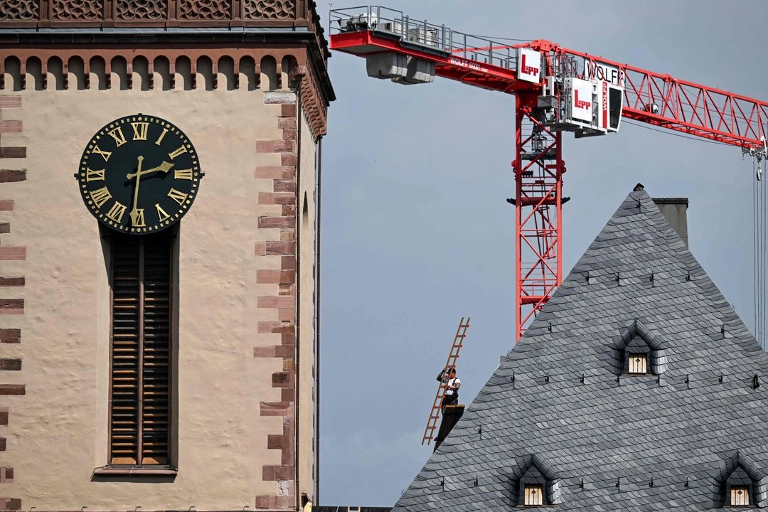 Un empleado lleva una escalera en la cima de la iglesia evangélica luterana de Santa Catalina en Fráncfort del Meno, Alemania Occidental, el 23 de abril de 2025. Foto