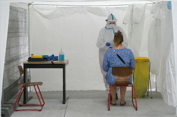 Personal médico de la Cruz Roja Alemana, DRK, usa un traje protector mientras realiza una prueba de coronavirus en una estación de prueba recién instalada en la estación principal de trenes de Berlín, Alemania. Foto Ap