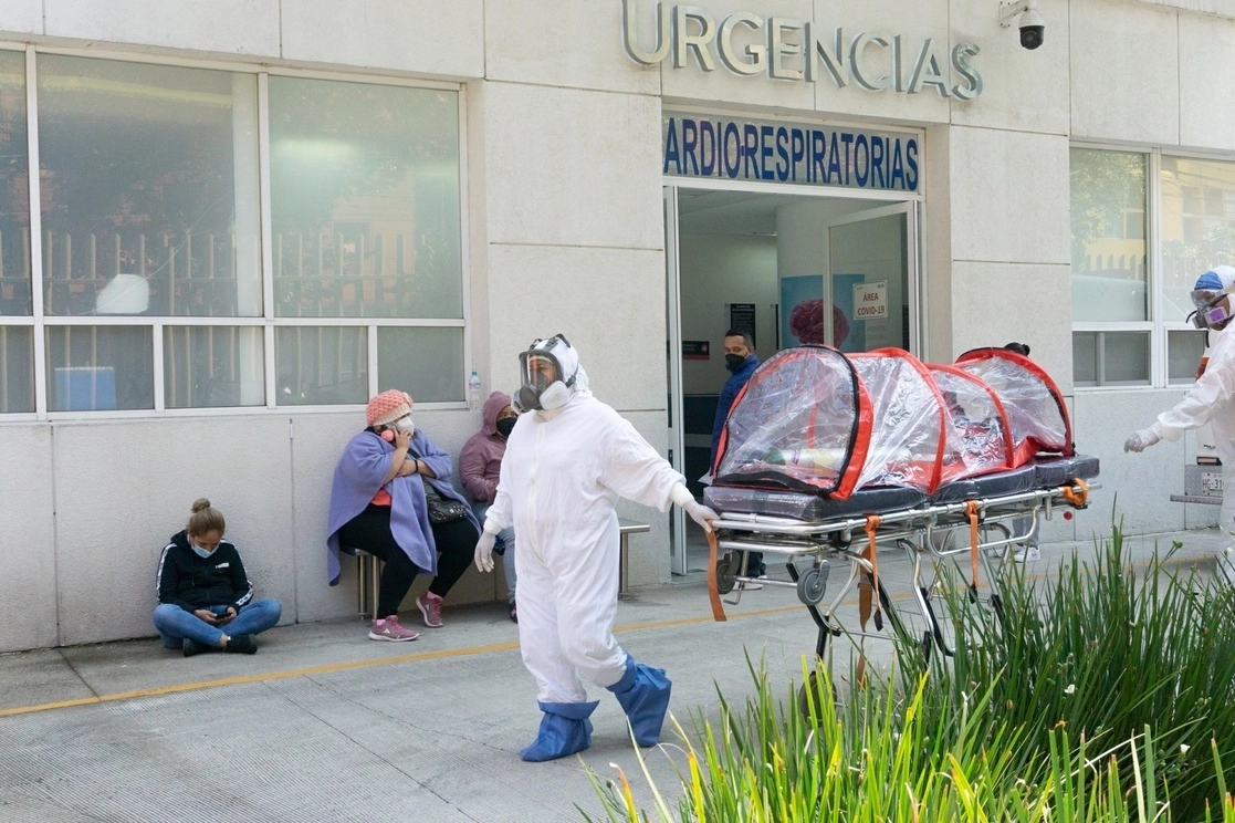 Personal médico traslada una camilla especial para pacientes con covid-19 hacia una ambulancia estacionada al exterior del área de Urgencias Cardio-Respiratorias del Hospital General de México, en la capital del país, en imagen de archivo. Foto Pablo Ramos