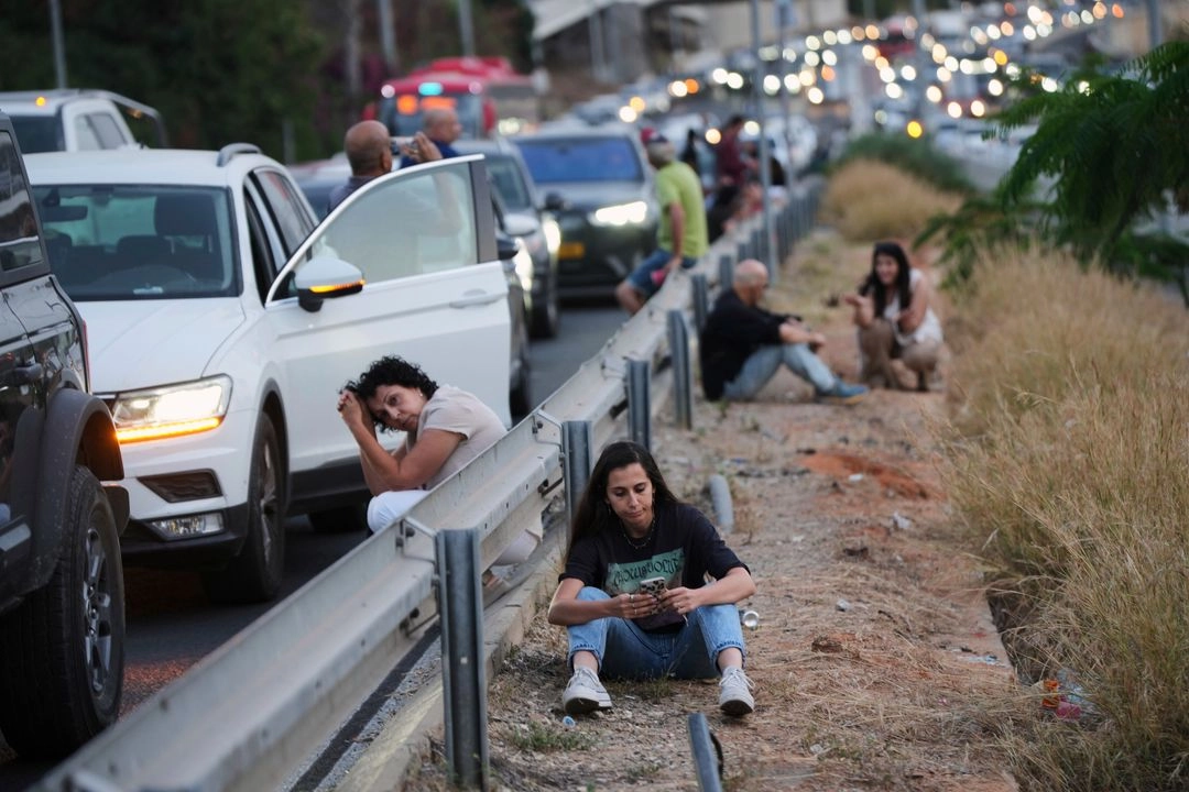La gente se refugia al costado de una carretera mientras suena una sirena de advertencia tras el lanzamiento de un misil desde Yemen, en Tel Aviv, Israel, el 3 de mayo de 2025. Foto