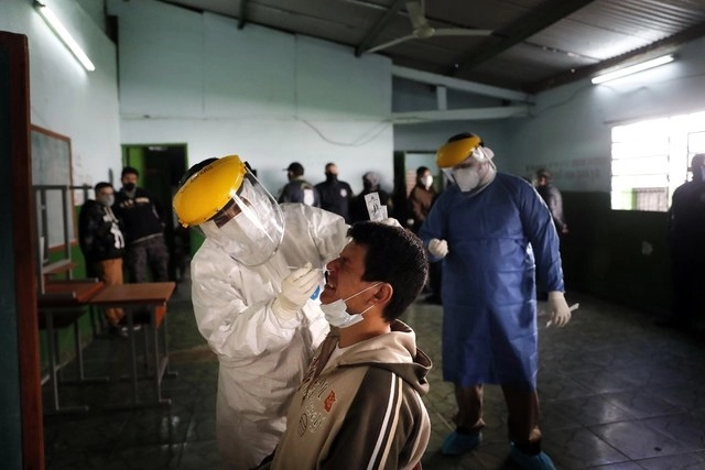Enfermera toma muestra para realizar prueba de detección de Covid-19 a interno del penal de Tucambú, en Asunción, Paraguay. Foto Ap
