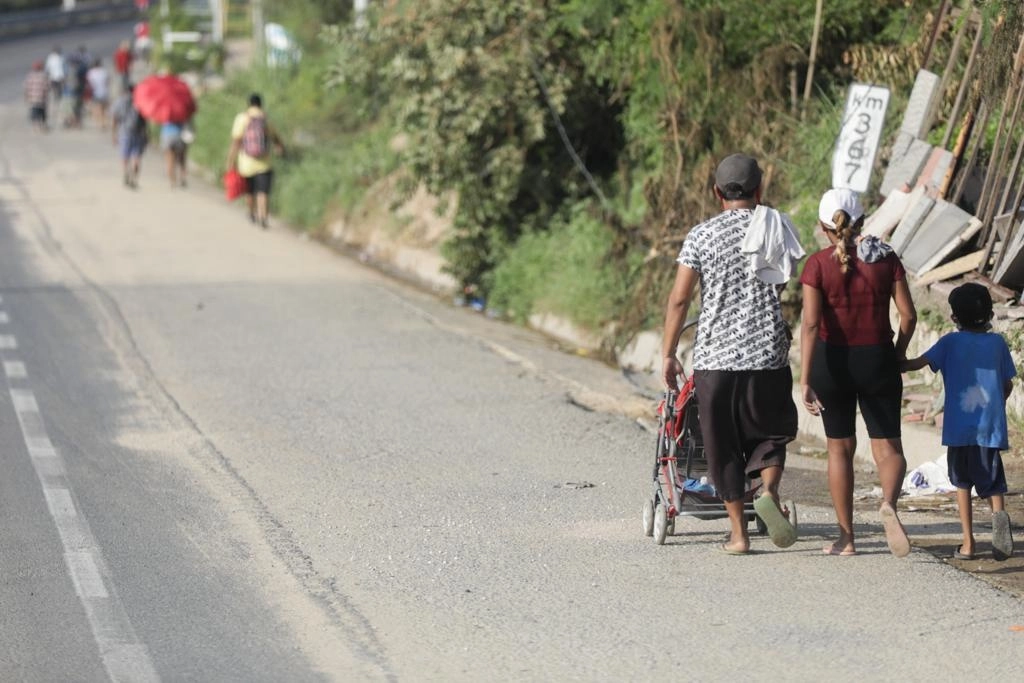 Una familia camina en carretera en búsqueda de víveres en Acapulco, Guerrero, el 29 de octubre de 2023. Foto Pablo Ramos 


