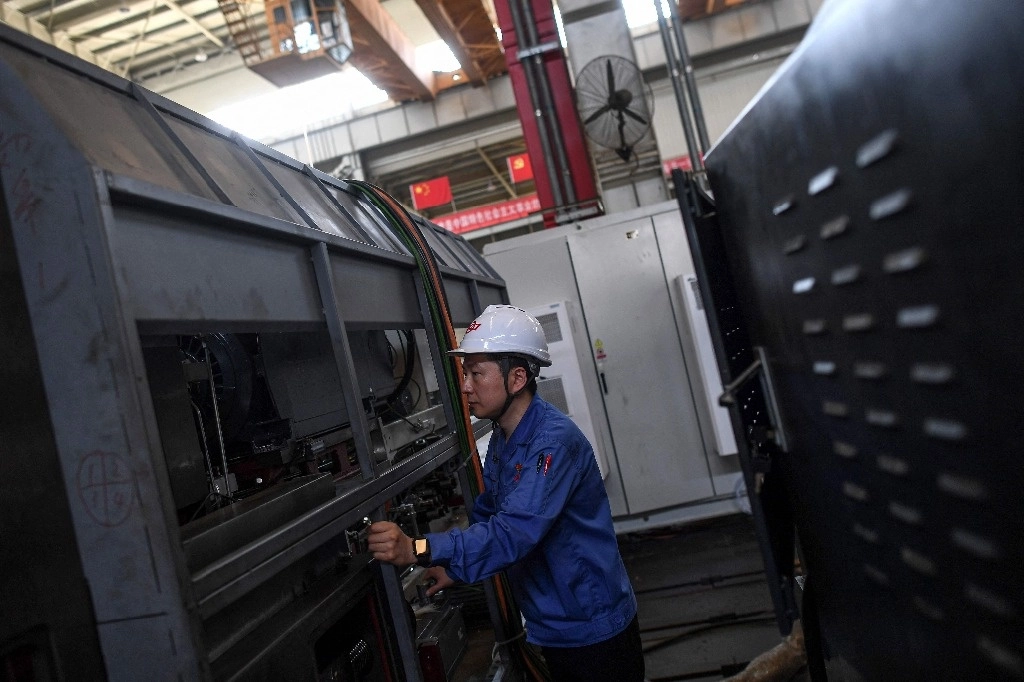 Esta foto tomada el 8 de mayo de 2024 muestra a un empleado trabajando en una línea de producción de máquinas de torno en una fábrica de máquinas herramienta de alta resistencia de China North Industries Group Corporation Limited (NORINCO Group) en Wuhan, en la provincia central de Hubei en China. Foto Afp