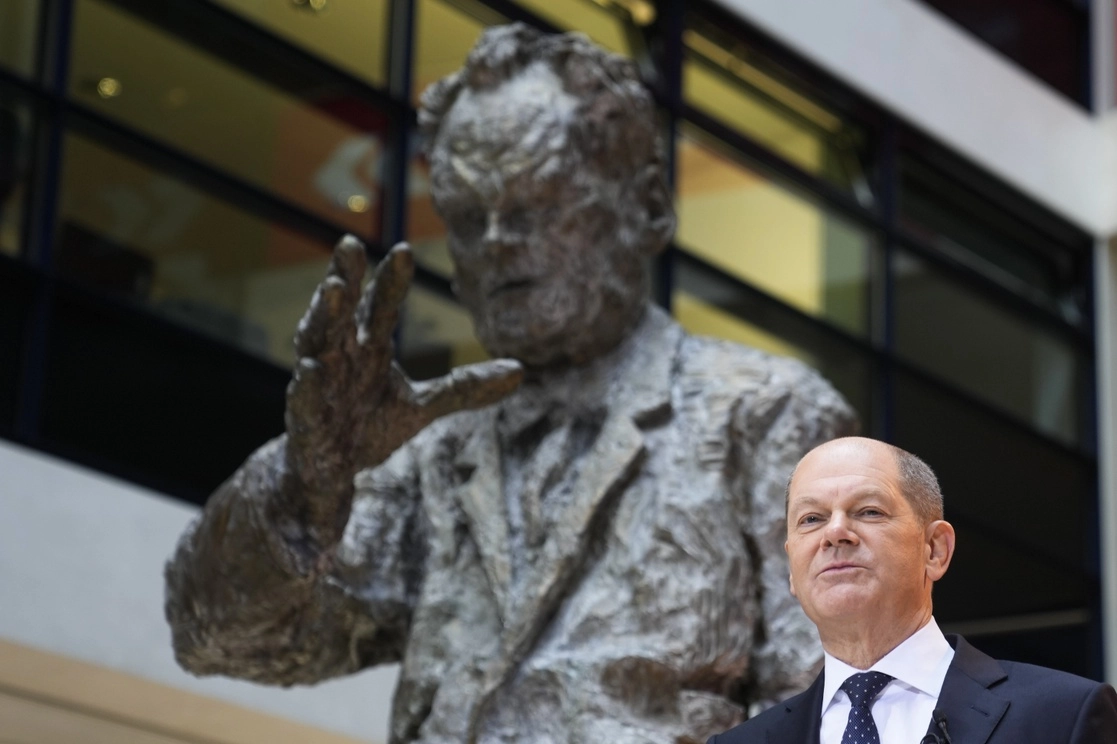 El líder de centroizquierda, Olaf Scholz, frente a una estatua del ex canciller Billy Brandt, hoy en Berlín, Alemania. Foto Ap 