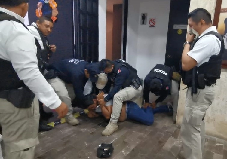 Elementos de la policía estatal de Campeche inmovilizan a una de las 35 personas que ingresaron por la fuerza al Congreso local, la madrugada de ayer, para apropiarse de documentos contables. Foto ‘La Jornada’