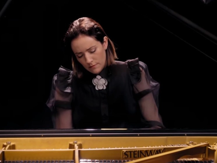 La directora, que creó y produjo La Orquesta Imposible, toca el piano en este concierto y realizó el arreglo de la creación de Arturo Márquez. Imagen tomada del concierto transmitido a través de Youtube de La Orquesta Imposible