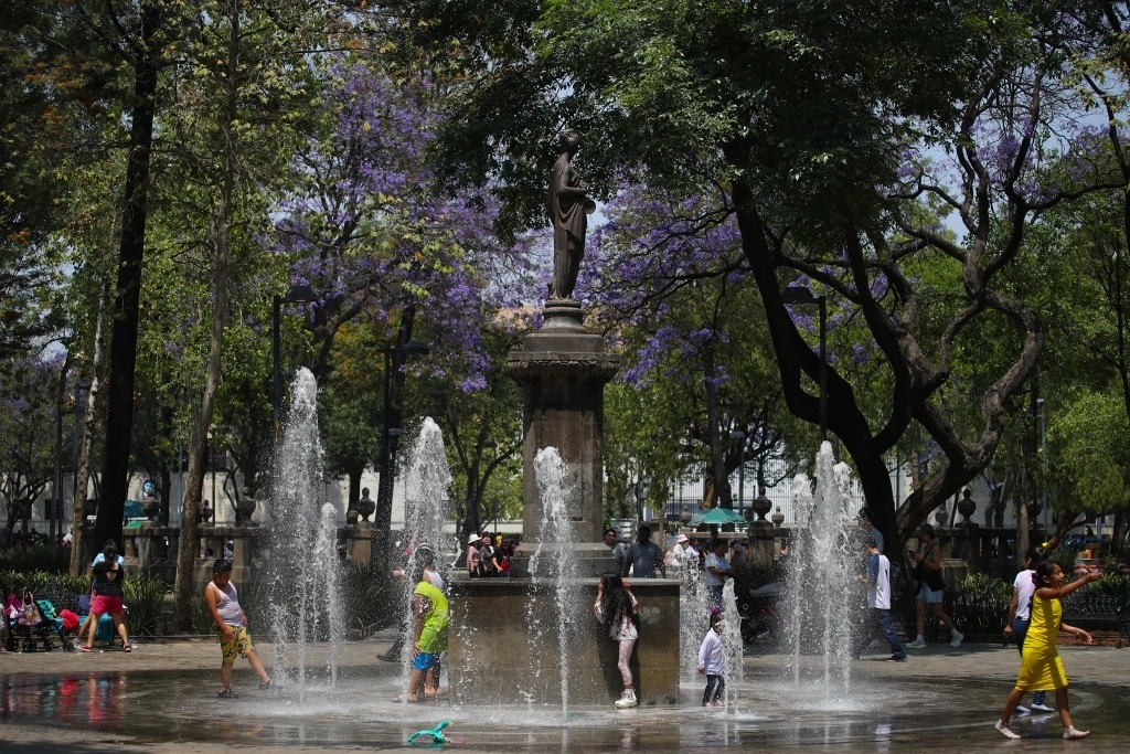 Personas se refrescan en una de las fuentes de la Alameda Central de la CDMX. Foto Yazmín Ortega