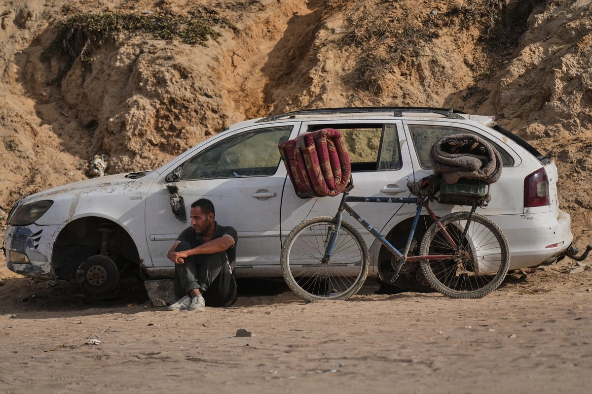 Palestino desplazado espera en la carretera costera cerca de Wadi Gaza, en el centro de la franja de Gaza, luego que se dio a conocer el acuerdo de alto al fuego con Israel, el jueves 9 de octubre de 2025. Foto 