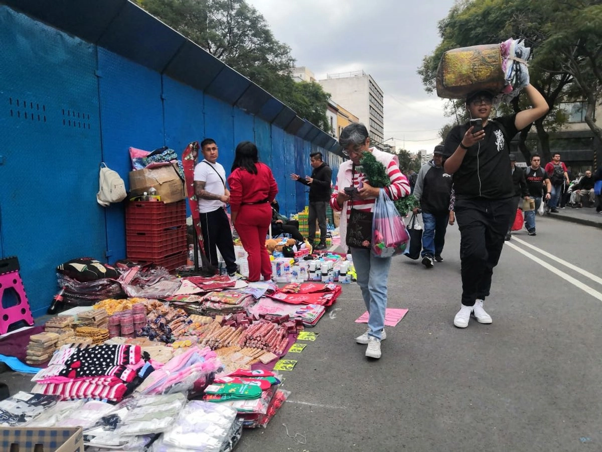 Los muros metálicos que obstaculizan el tránsito en el Centro Histórico no impiden que comerciantes ambulantes extiendan su mercancía en la zona.