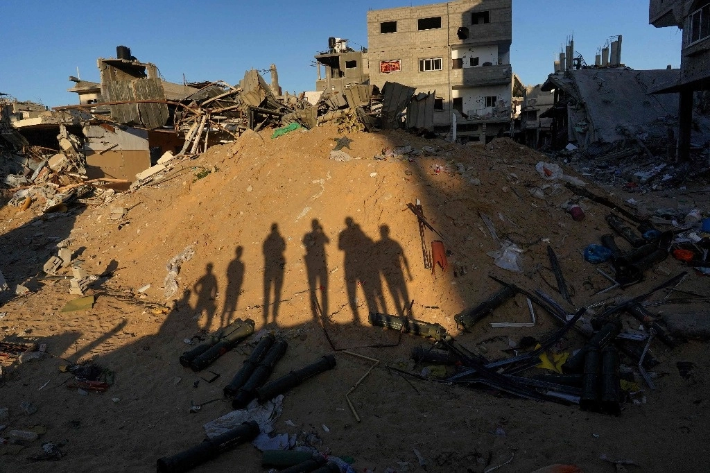Niños palestinos reúnen contenedores vacíos de municiones estadunidenses en Khan Yunis, en el sur de la Franja de Gaza, el 16 de mayo de 2024. Foto Afp