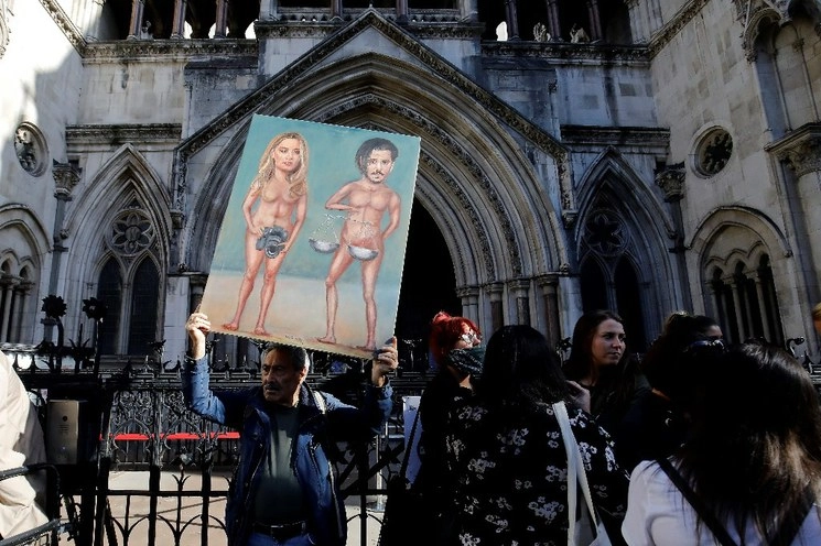 El artista de la sátira política Kaya Mar se encuentra con una pintura que representa al actor estadounidense Johnny Depp y su ex esposa Amber Heard, en el décimo día del juicio por difamación de Depp contra News Group Newspapers (NGN), en el Tribunal Superior de Londres, el 20 de julio de 2020. Foto Afp
