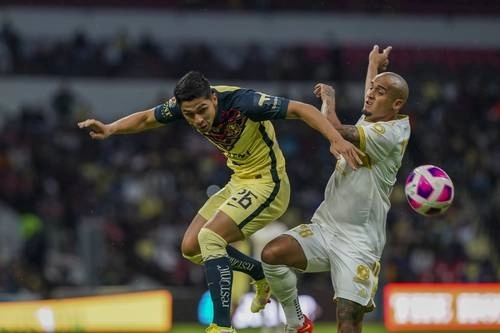 Salvador Reyes, del América, y Luis Rodríguez, de Tigres, luchan por el balón durante el juego de ayer en el Azteca. Foto Ap