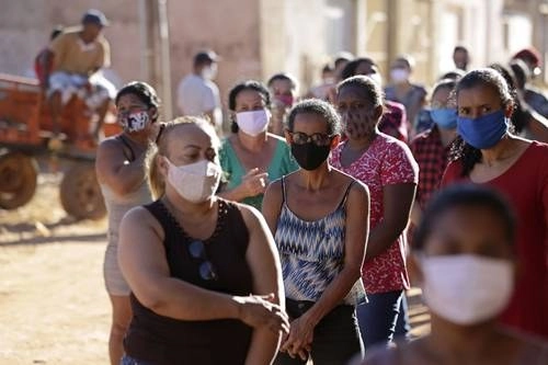 Organizaciones civiles de asistencia acuden a los barrios pobres de Brasilia para regalar alimentos y productos básicos. Las personas aguardan en largas filas para recibir la ayuda. Brasil ha reportado dos millones 707 mil 877 contagios y 94 mil 104 muertos por la pandemia.Foto Ap