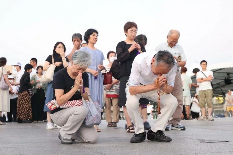 Visitantes rezan en el cenotafio en honor a las víctimas de la bomba atómica en el Parque Conmemorativo de la Paz, en la ciudad japonesa de Hiroshima, al cumplirse 78 años del primer ataque con esta arma en el mundo, perpetrado por Estados Unidos que dejó más de 100 mil civiles muertos. Este aniversario casi no fue reportado en los portales de los principales medios de este país. Foto Jiji Press vía Afp