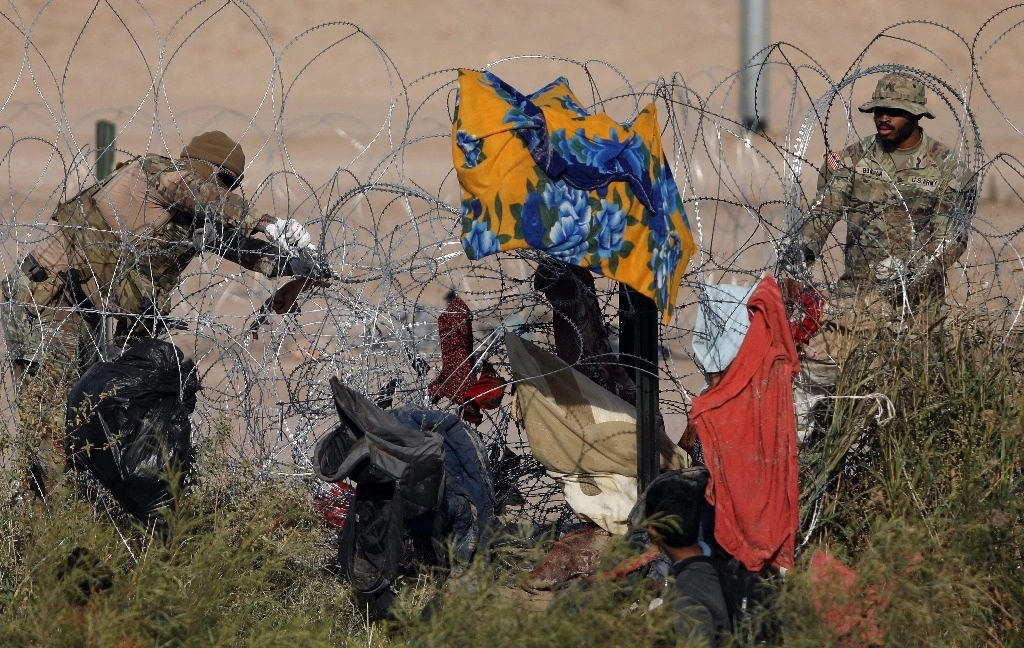 Agentes texanos de la Guardia Nacional colocan alambre de púas en las orillas del río Bravo, contra el cruce de indocumentados desde Ciudad Juárez, Chihuahua. En el Día de los Derechos Humanos, es importante subrayar que Estados Unidos es el país que menos tratados ha ratificado en la materia, incluidos los migratorios. Foto Afp 
