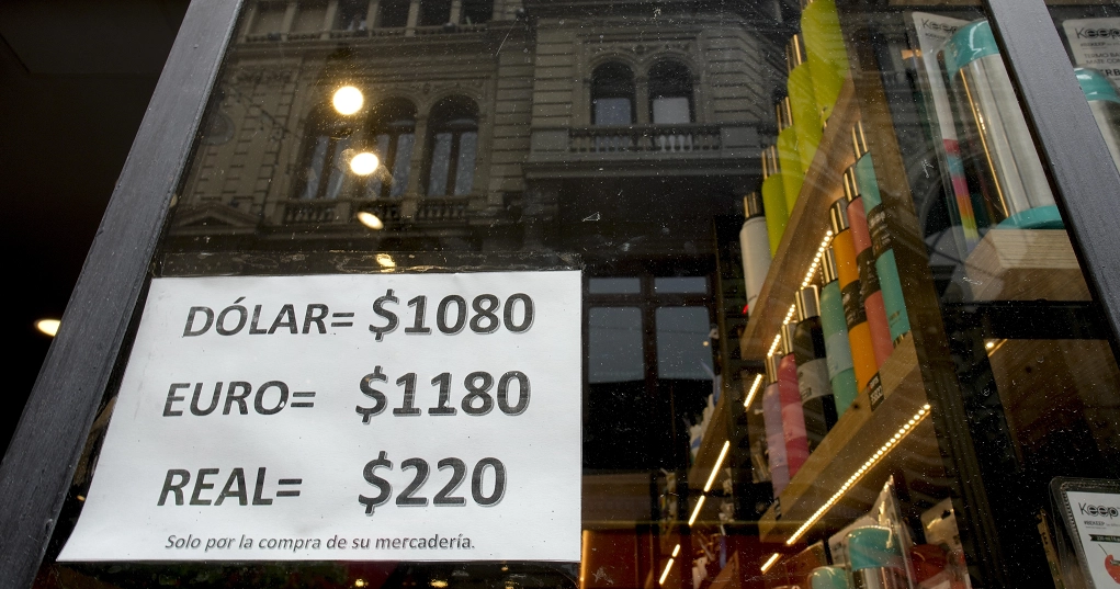 Un letrero muestra el tipo de cambio de dólares, euros y pesos, en un escaparate en Buenos Aires, Argentina, tras el devaluó del peso, en un 50%, decretado por el gobierno como parte de las medidas de choque del nuevo presidente, Javier Milei. Foto AP