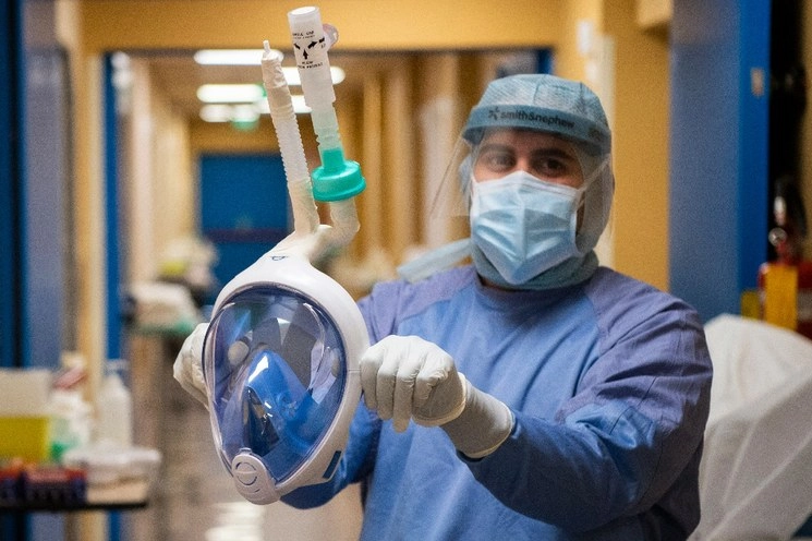 Un médico muestra una máscara de snorkel que se convirtió en una máscara médica para ser conectada a una máquina de ventilación. Foto AP 