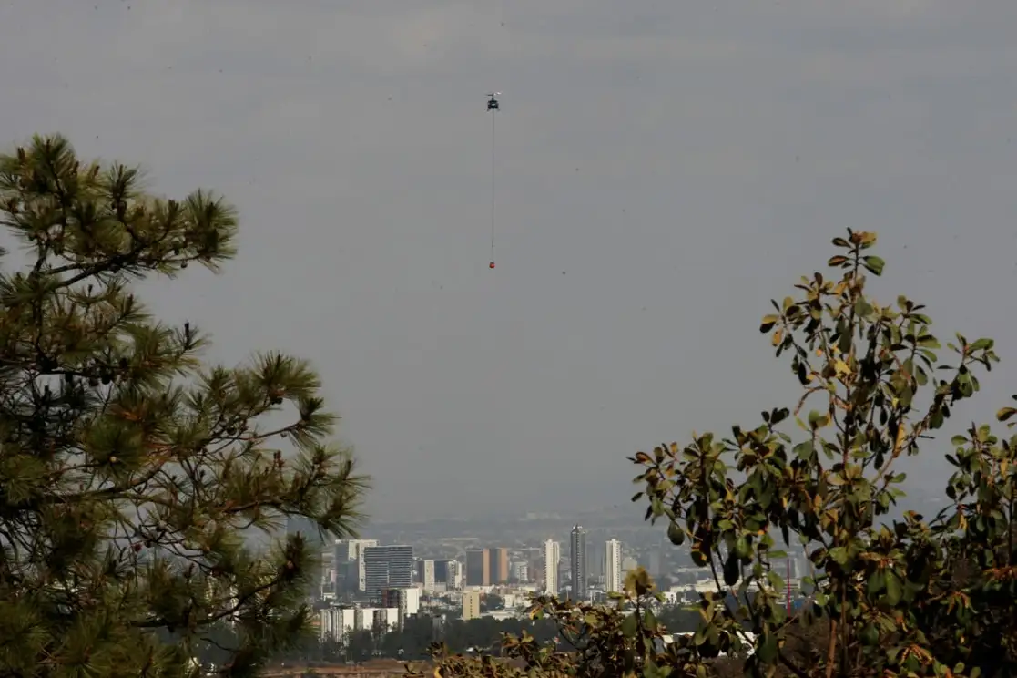 Se mantiene la alerta atmosférica en la zona de valles del Área Metropolitana de Guadalajara debido al incendio en el bosque de La Primavera. En la imagen, un helicóptero se moviliza para combatir el fuego. Foto Arturo Campos Cedillo