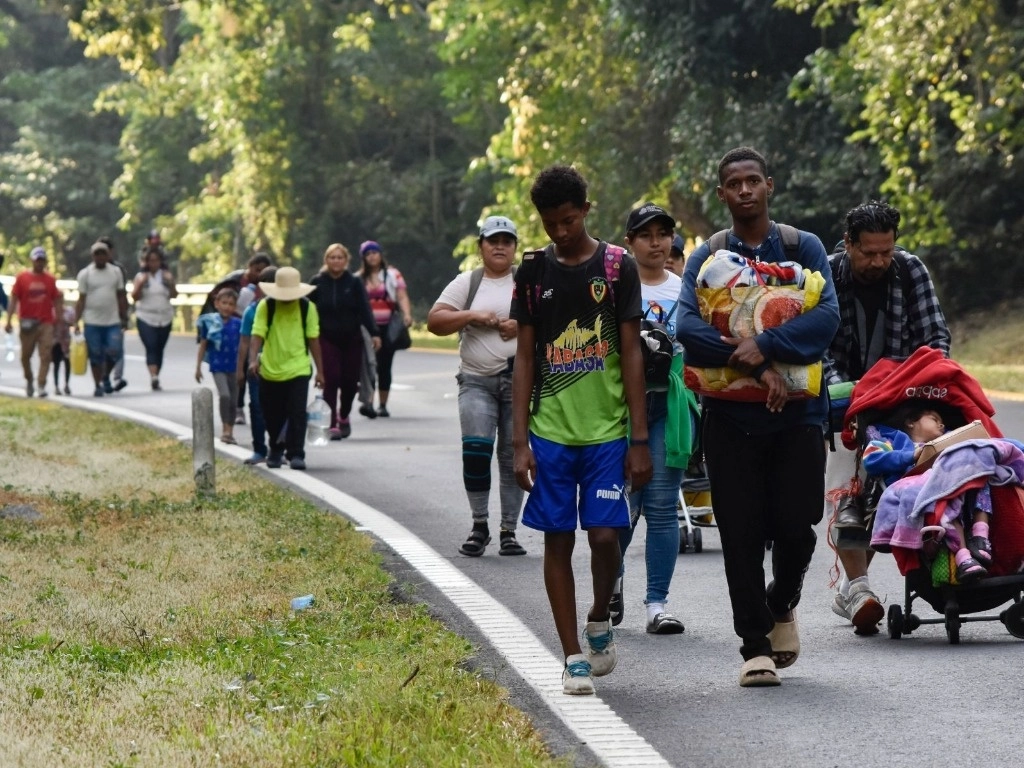 Migrantes caminan al costado de la carretera a través de Villa Comaltitlán, estado de Chiapas, sur de México, el 27 de diciembre de 2023, mientras se dirigen al norte hacia la frontera con Estados Unidos. Foto Ap / Edgar H. Clemente