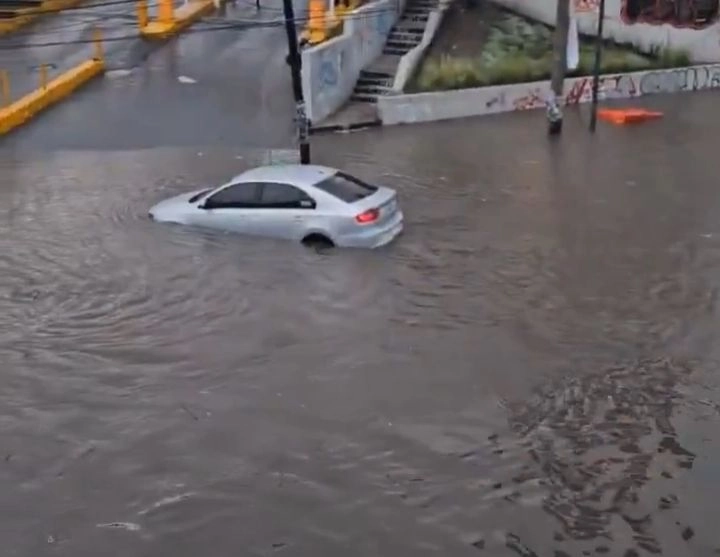 A la altura de Plaza Coacalco y a desnivel, se observan otros dos vehículos varados en la inundación. Incluso un auto flota y es golpeado por el oleaje que provocan camiones de carga y de transporte público, en una zona donde el nivel de la acumulación está por arriba de los 40 centímetros. Foto 