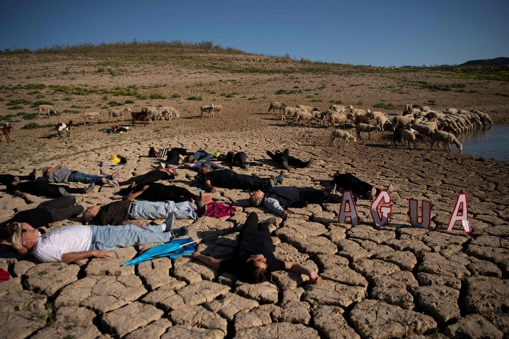 Activistas yacen en el suelo seco durante una manifestación ambiental de Acción Climática Global. Foto Afp